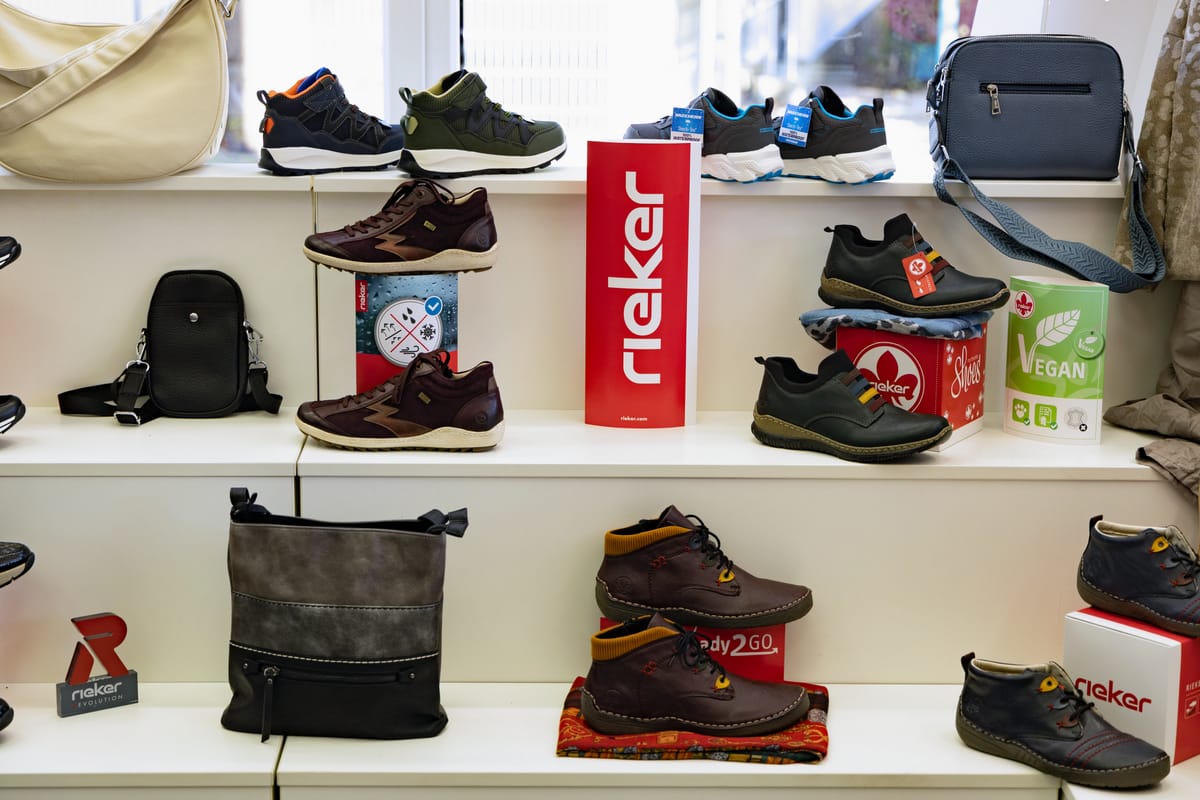 Rieker-Regal mit Halbschuhen, Sneakern und Taschen
