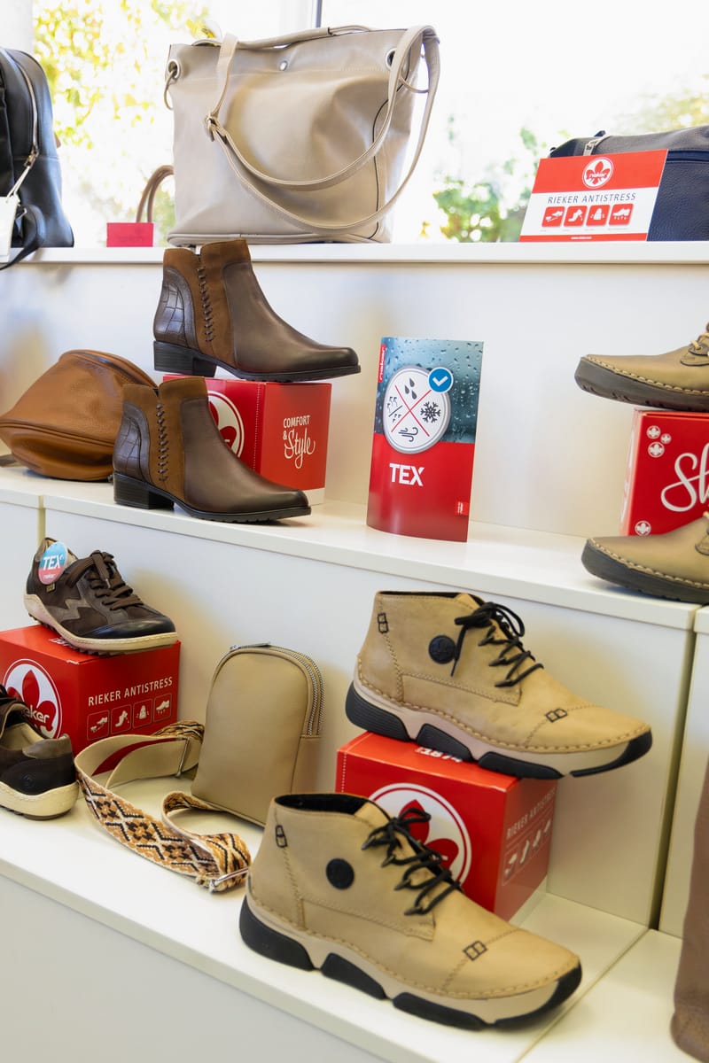 Stiefeletten und Schnürschuhe im weißen Wandregal