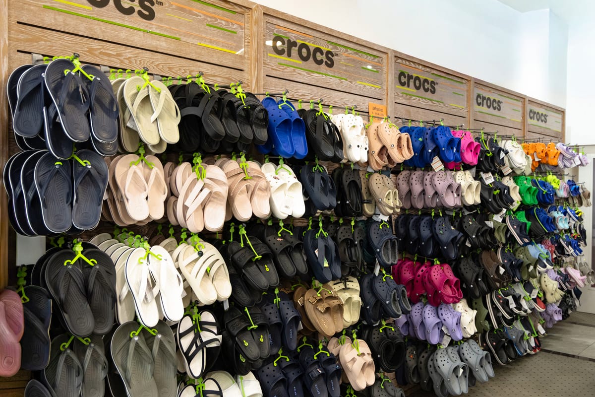 Crocs-Wand mit Flip-Flops, Sandalen und Clogs